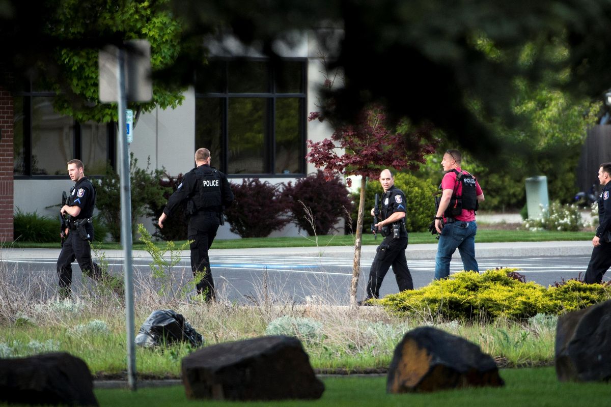 Law enforcement search for a suspect at Division Street and Cozza Ave. in Spokane on Thursday. (Colin Mulvany / The Spokesman-Review)