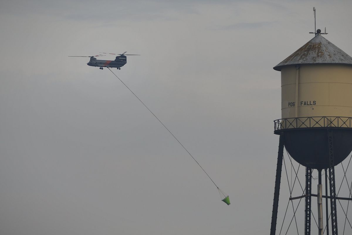 A helicopter returns to fill its bucket Friday afternoon while fighting the Parkway Fire in Post Falls. Evacuation orders for the area were lifted Sunday.  (Colin Tiernan/The Spokesman-Review)