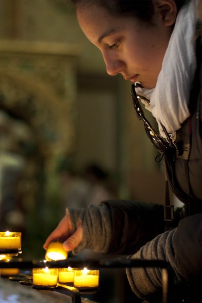 A worshipper lights a candle during a Good Friday service in Amsterdam on Friday. (Associated Press)