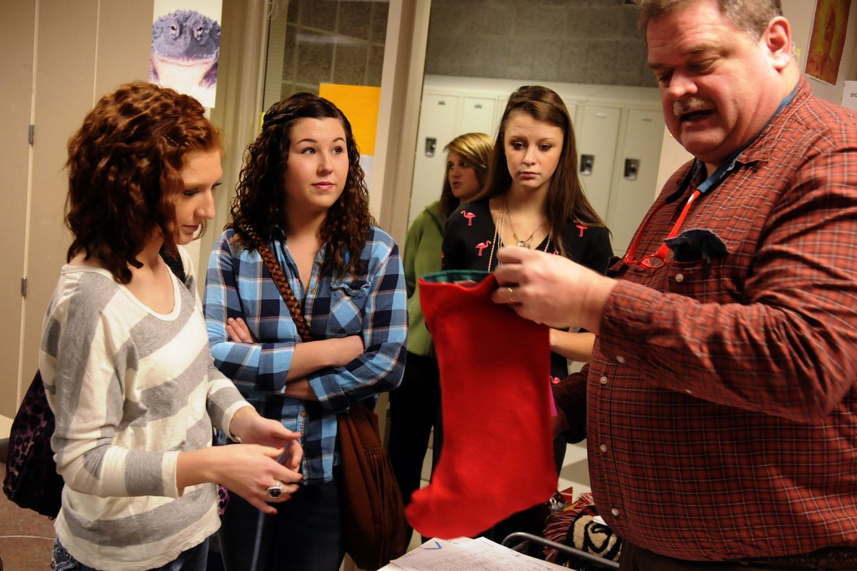 University High School leadership class adviser Wally Watson looks at a Christmas stocking donated by students for the school’s annual Adopt-A-Tot drive. For over 20 years, U-Hi students have collected holiday gifts for underprivileged children in the area. (J. Bart Rayniak)