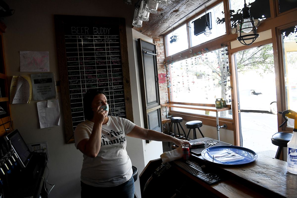 Melinda Dolmage, owner of The Lantern Tap House takes a phone call on Wednesday, September 30, 2020, at The Lantern Tap House in the Perry District of Spokane, Wash. The same group of thieves broke into the back of the business again Tuesday night, this time through a back door using the brick pictured in the foreground.  (Tyler Tjomsland/THE SPOKESMAN-REVIEW)