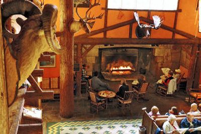 
Inside the lobby of the Lake McDonald Lodge is a large fireplace. Around the fireplace opening, figures and symbols have been carved into the facing. 
 (Mike Brodwater Handle Extra / The Spokesman-Review)