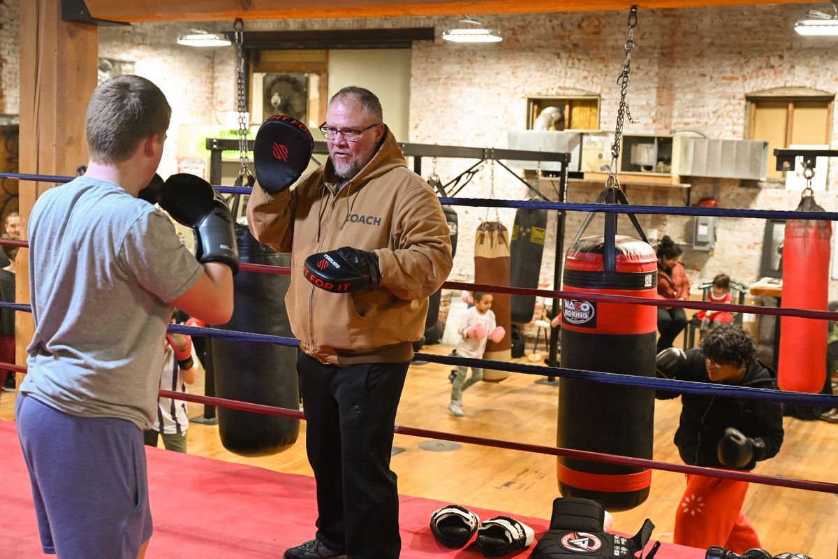 Longtime boxer and boxing coach Rick Welliver works with William Tombari, 12, during a session at Spokane Boxing on Tuesday.  (Jesse Tinsley/THE SPOKESMAN-REVI)