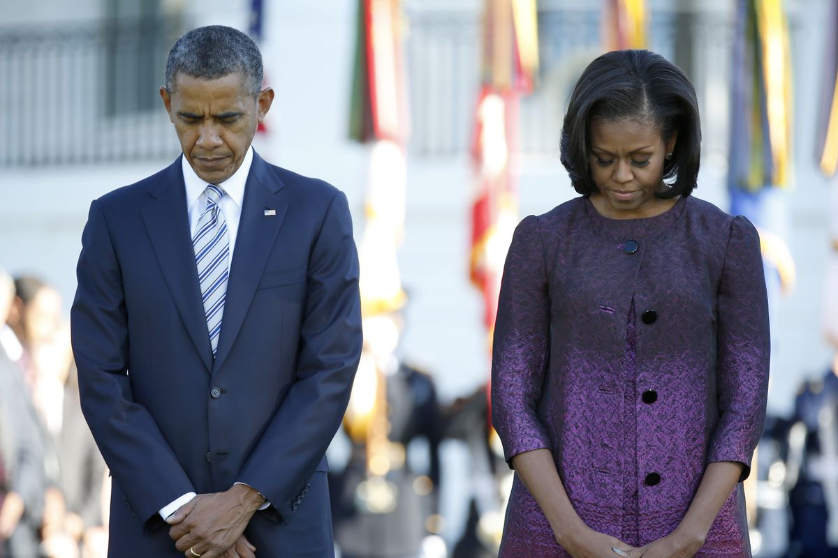 President Barack Obama and first lady Michelle Obama, joined by members of the White House staff pause during a moment of silence to mark the 11th anniversary of the Sept, 11th, Tuesday, Sept. 11, 2012, on the South Lawn of the White House in Washington. (Carolyn Kaster / Associated Press)