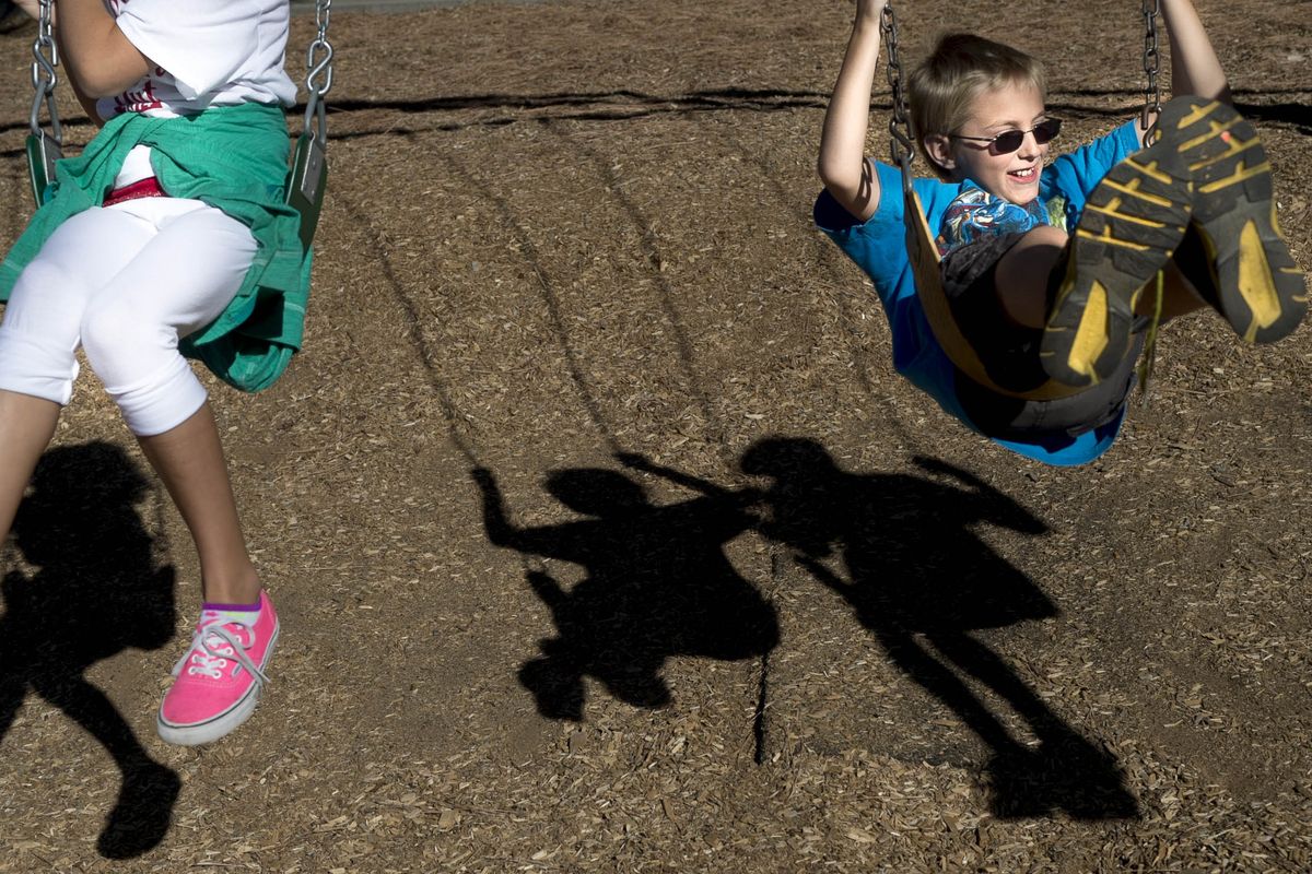 Elementary schooler Brendan Washington swings with friends on Monday at Hamblen Elementary in Spokane. (Tyler Tjomsland)