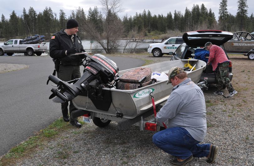 Spokane County Sheriff Deputy Jay Bailey checks the boat of anglers before they launch at West Medical Lake on Saturday. The opening day of the lowland lake fishing season is a good opportunity for the deputies to contact a large number of boaters to be sure their boats are up to snuff. Requirements include: Current registration on board, registration numbers properly shown, boat drivers 35 and under need boater education certificate, life jackets for everyone in the boat and functioning fire extinguisher.  (Rich Landers)