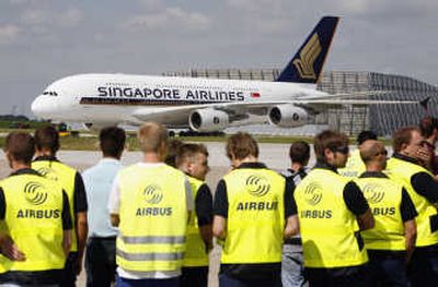 
Employees watch as the first Airbus A380 for Singapore Airlines rolls up for takeoff from the Airbus plant in Hamburg, Germany.  Airbus will  hand over its first A380 superjumbo to the airline Monday. Associated Press
 (File Associated Press / The Spokesman-Review)