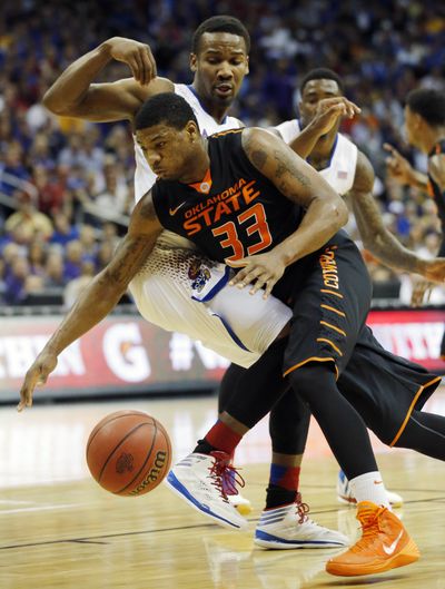 Oklahoma State guard Marcus Smart (33) is fouled by Kansas guard Wayne Selden, Jr., back, during the first half of an NCAA college basketball game in the quarterfinals of the Big 12 Conference men's tournament in Kansas City, Mo., last Thursday. (Associated Press)