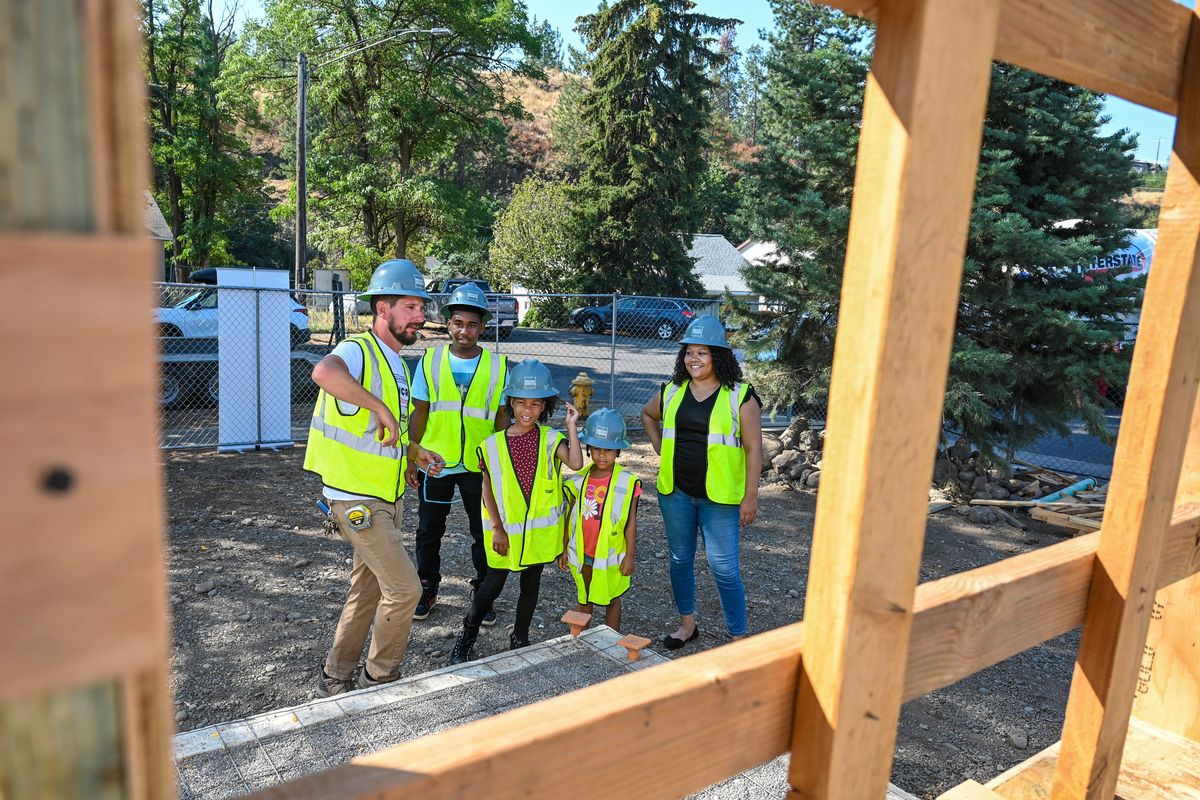 Habitat for Humanity senior construction supervisor Jonathan Balazs, left shows Kelsey McCarthy, right, and her three children, second from left, Kahree Bowens, 15, Annabelle McCarthy, 8, and Trinity McCarthy, 6, the interior of their new Habitat for Humanity home, Friday, Sept.2, 2022 in the East Central area of Spokane.  (DAN PELLE/THE SPOKESMAN-REVIEW)