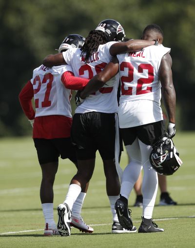 In this photo taken Monday, July, 22, 2019, Atlanta Falcons defensive back J.J. Wilcox (29) is helped off the field by teammates Damontae Kazee (27) and strong safety Keanu Neal (22) after being injured during their NFL training camp football practice Monday, July 22, 2019, in Flowery Branch, Ga. (John Bazemore / Associated Press)