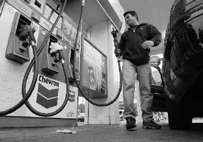
Taxi cab driver Fred Costa finishes pumping gas at a Chevron gas station in San Francisco on Thursday. Chevron Corp.'s fourth-quarter profit dropped by nine percent, but the oil company still made enough to post its third consecutive year of record earnings.
 (Associated Press / The Spokesman-Review)