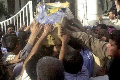 
Iraqis carry a coffin with the remains of the chairman of the Iraqi Governing Council, Izzadine Saleem, into his family house, after the coffin was brought from Baghdad to Basra, southern Iraq, last week.
 (Associated Press / The Spokesman-Review)