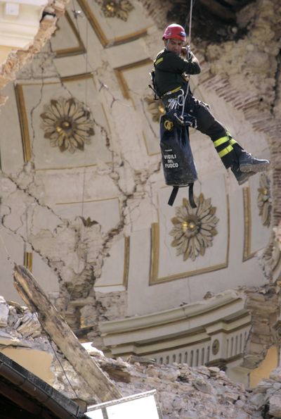 Firefighter Roberto Contu inspects damage to the church of Santa Maria del Suffragio, in L’Aquila, Italy, on Wednesday. At least 272 have been killed by Monday’s powerful quake. (Associated Press / The Spokesman-Review)
