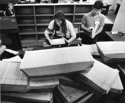 Dale Petrie and Debra Ottosen open some of the 40,000 census forms that arrived at the U.S. Census office in Spokane for the 1990 census. (Colin Mulvany / The Spokesman-Review)