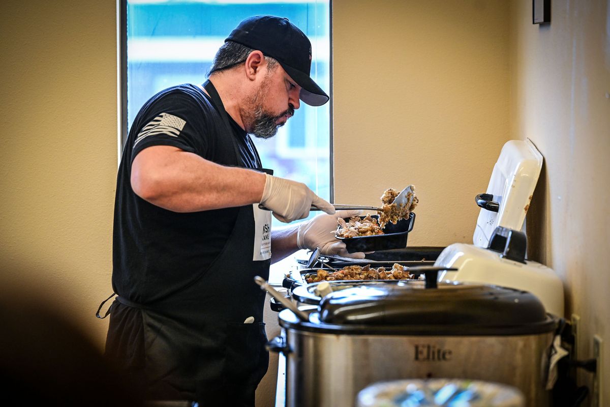 Nourish Spokane Community Soup Kitchen and Pantry volunteer Jason Healey prepares a Thanksgiving dinner to-go box Saturday in Spokane Valley. (Dan Pelle/For The Spokesman-Review)