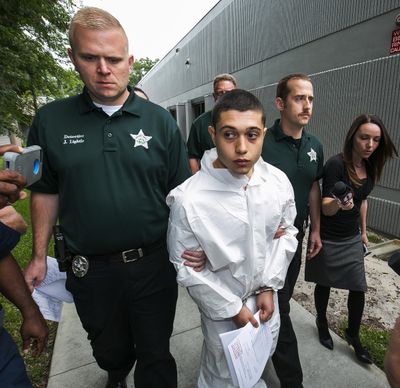 Marion County Sheriff’s Detectives John Lightle, left, and Dan Pinder, right, escort a handcuffed and shackled Sky Bouche, 19, center, to a waiting patrol car, Friday, April 20, 2018, in Ocala, Fla. Bouche is the suspect in a shooting that occurred at Forest High School on Friday morning. (Doug Engle / Ocala Star-Banner)