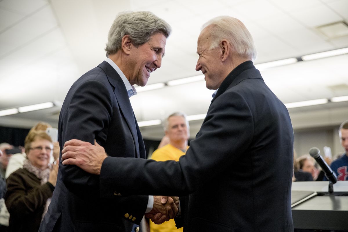 FILE - In this Feb. 1, 2020, file photo Democratic presidential candidate former Vice President Joe Biden smiles as former Secretary of State John Kerry, left, takes the podium to speak at a campaign stop at the South Slope Community Center in North Liberty, Iowa.  (Andrew Harnik)
