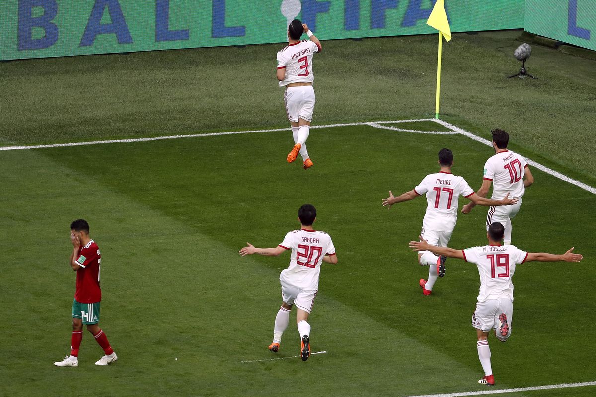 Morocco’s Mbark Boussoufa, left, reacts as players of Iran celebrate the opening goal during the group B match between Morocco and Iran at the 2018 soccer World Cup in the St. Petersburg Stadium in St. Petersburg, Russia, Friday, June 15, 2018. (Darko Vojinovic / Associated Press)
