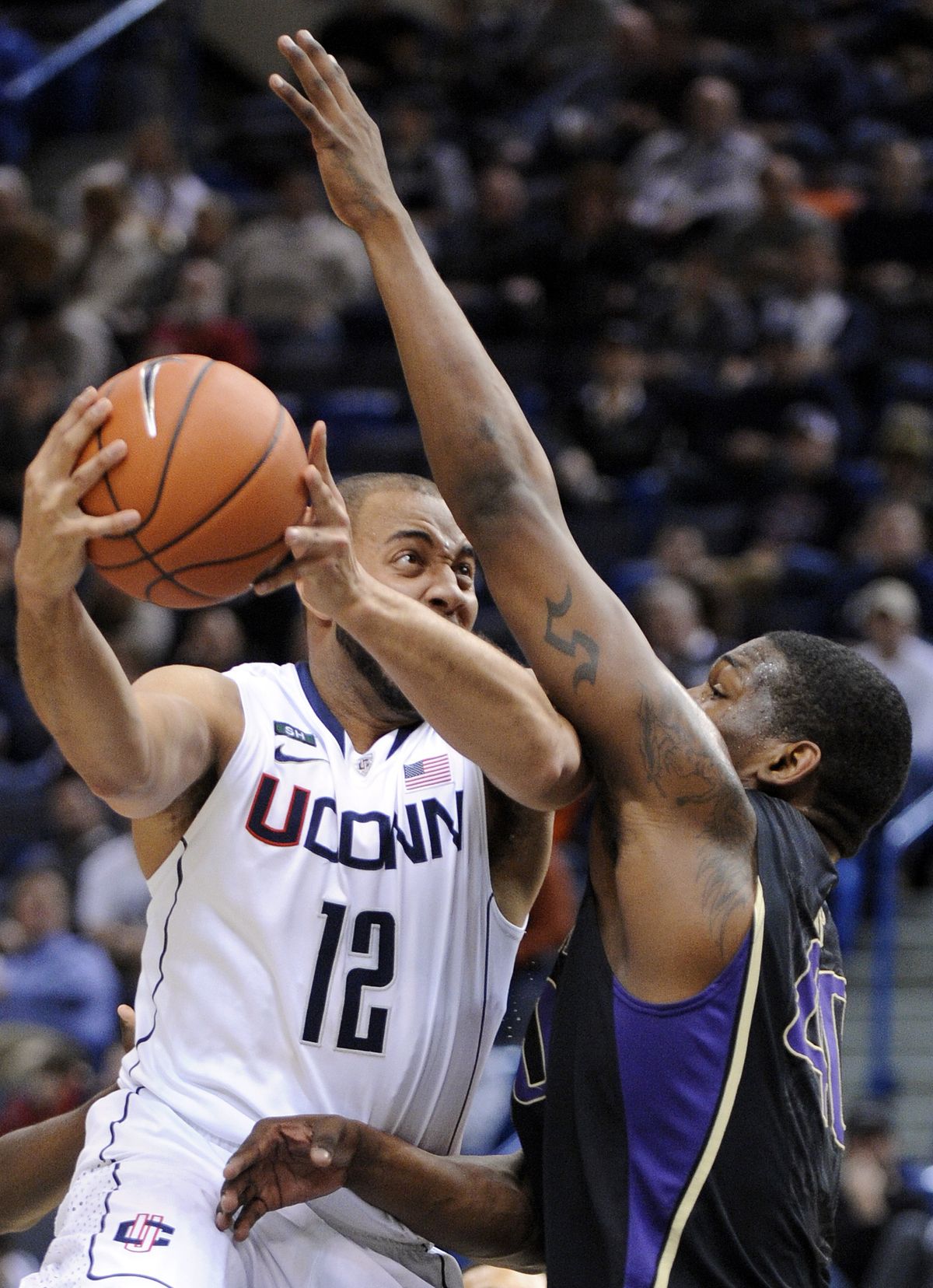 Connecticut reserve guard R.J. Evans drives past Washington’s Shawn Kemp Jr. (Associated Press)