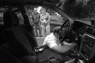 
Troy and Monica Gilbert watch Aspen Sound technician Brandon Folk as he installs a GPS device, on seat, in their car. The Gilberts will have one unit in their car and another one installed in the car their son Kurt uses. 
 (Christopher Anderson / The Spokesman-Review)