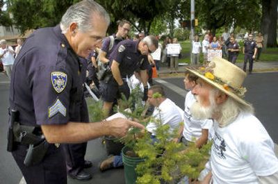 Medford police Sgt. Bob Sergi warns protester Don Shawe that he will be arrested if he doesn't stop blocking traffic Monday in front of U.S. Forest Service offices in Medford, Ore.
(Associated Press / The Spokesman-Review)