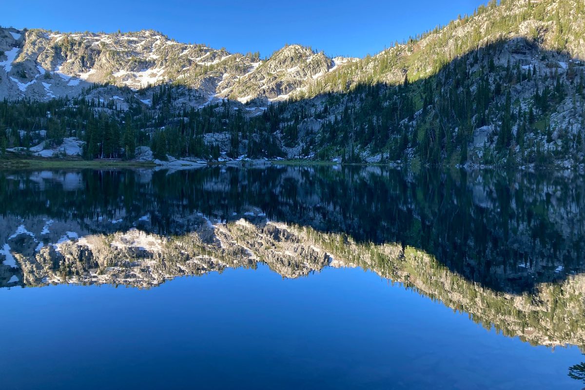 Heaven and earth are reflected in the dawn’s early light at Steamboat Lake in the Wallowa mountains of northeastern Oregon.  (Photo by Kim Guida)