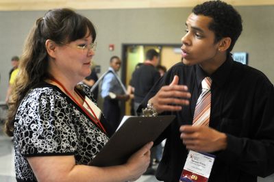 University High School student Spencer White tries to sell Cecelia White, of Inland Northwest Health Services, on his idea for a new health clinic Friday at Business Week, a business-education program for high school students. (Jesse Tinsley / The Spokesman-Review)