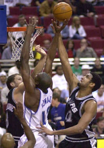
San Antonio's Rasho Nesterovic, left, and Tim Duncan, right, battle Orlando's Dwight Howard for a rebound on Wednesday.
 (Associated Press / The Spokesman-Review)