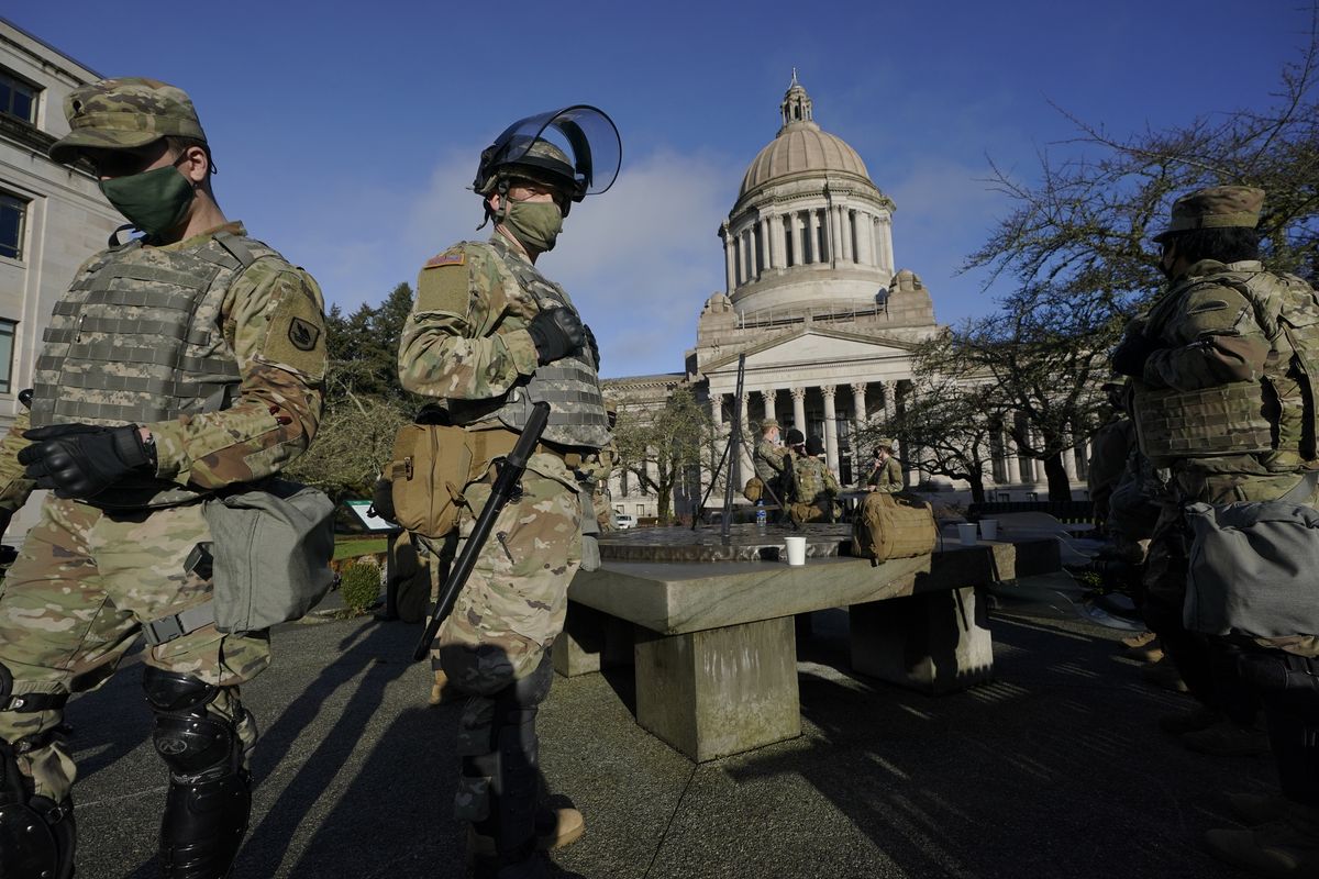 Members of the Washington National Guard stand at a sundial near the Legislative Building on Jan. 10 at the Capitol in Olympia.  (Ted S. Warren)