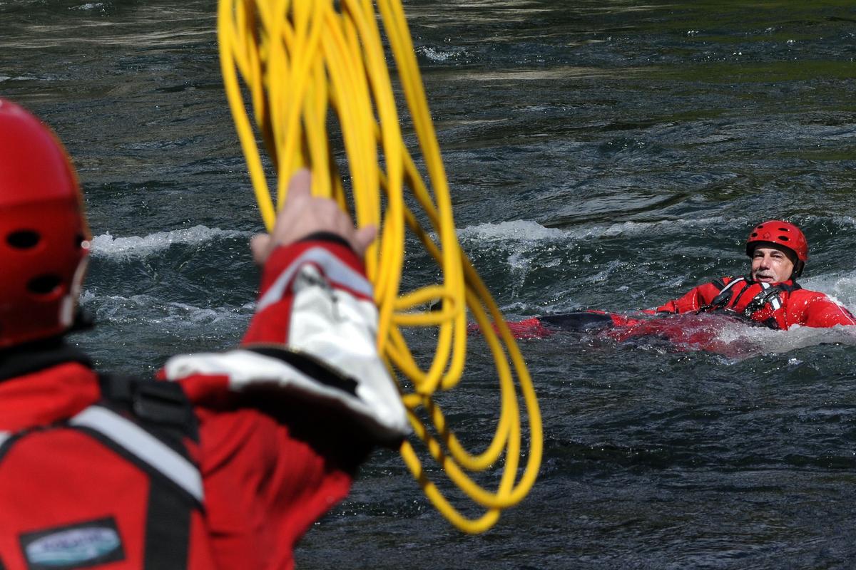 Spokane Valley firefighter Marty Ward watches for the line tossed by Matt Jorgensen during swift water rescue training in the Spokane Valley area of the Spokane River on May 13. (Kathy Plonka)