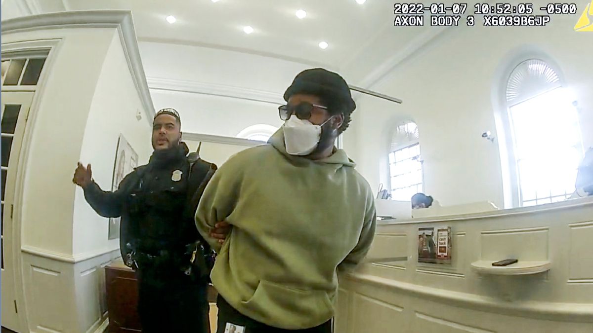A police officer detains "Black Panther" director Ryan Coogler at a Bank of America branch in Atlanta, in this January 2022 image made from Atlanta Police video. Coogler was mistaken for a bank robber at the bank. (HOGP)