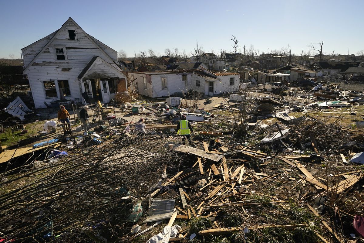 Voluteers help Martha Thomas, second left, salvage possessions from her destroyed home, in the aftermath of tornadoes that tore through the region, in Mayfield, Ky., Monday, Dec. 13, 2021. (Gerald Herbert)