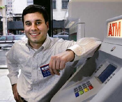 
Nick Sayers poses at an ATM machine in downtown Chicago. Sayers went into online banking about five months ago for the higher interest rates but now realizes it's just more convenient. 
 (Associated Press / The Spokesman-Review)