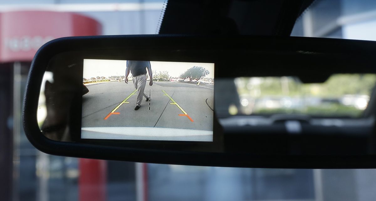 A new surveillance system that displays on the rearview mirror in police cars automatically sounds a chime, locks the doors and rolls up the windows if it detects someone approaching from behind. (Associated Press)