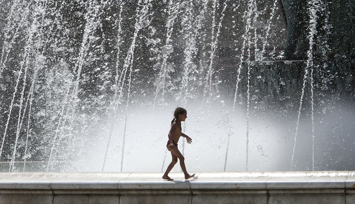 A girl walks on the edge of a fountain on a hot day in downtown Skopje, North Macedonia, Wednesday July 28, 2021. Authorities in North Macedonia have issued a weather warning and recommended a set of measures on Wednesday as the tiny Balkan country is facing extreme high temperatures rising over 43 Celsius degrees (109 Fahrenheit).  (Boris Grdanoski)