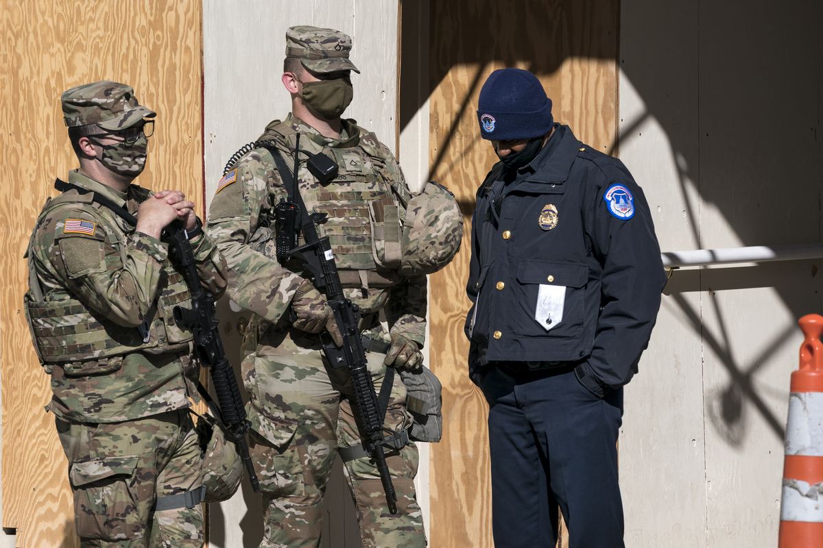 A U.S. Capitol Police officer, right, stands with two National Guard members near the scene where a fellow officer was killed after a man rammed a car into two officers at a barricade outside the U.S. Capitol and then emerged wielding a knife, on Capitol Hill in Washington, Friday, April 2, 2021.  (J. Scott Applewhite)