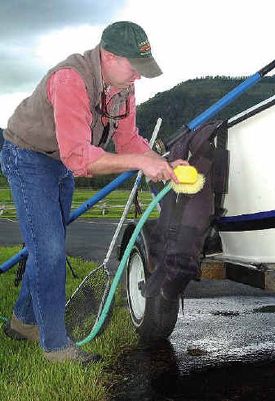 
Allen May of the Idaho Nature Conservancy demonstrates how to clean fishing equipment May 21, 2004, to help prevent the spread of exotic species at a Snake River launch site in Conant Valley, Idaho. 
 (Associated Press / The Spokesman-Review)