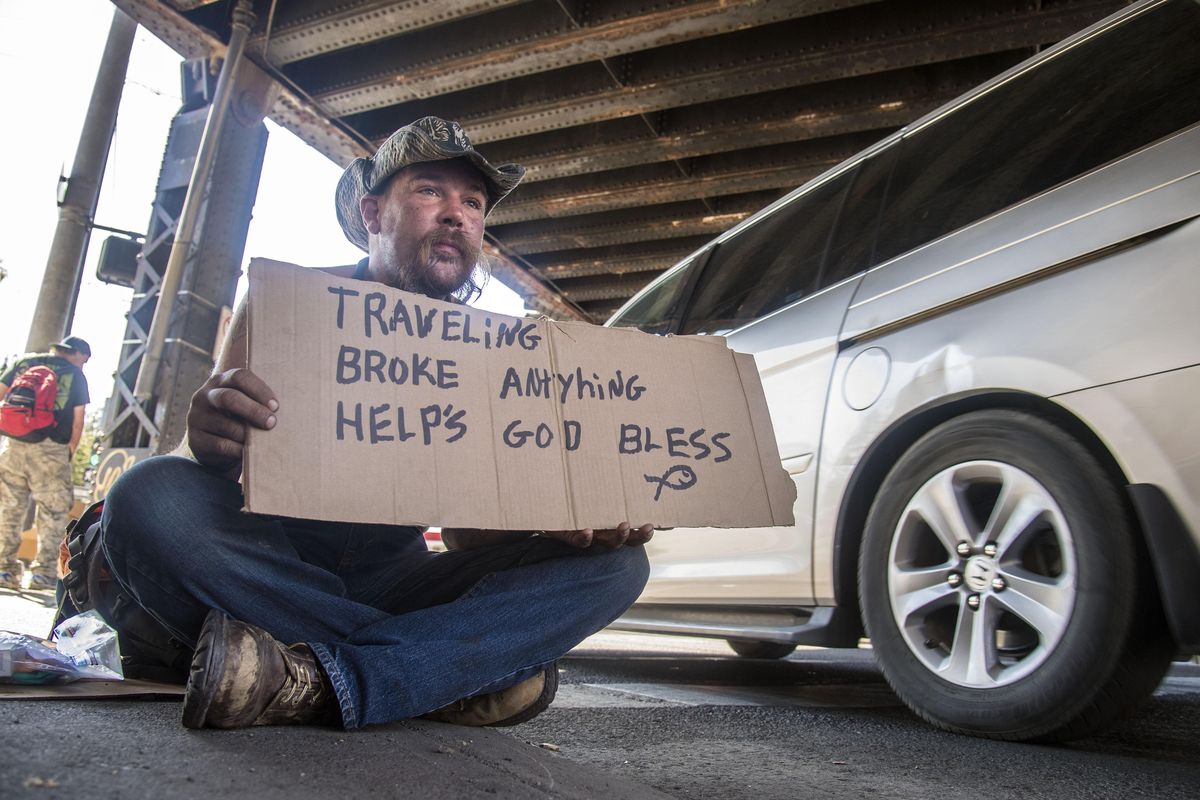 Nick (no last name given) sits on the corner of Maple Street and Second Avenue asking for money Monday. (Dan Pelle / The Spokesman-Review)