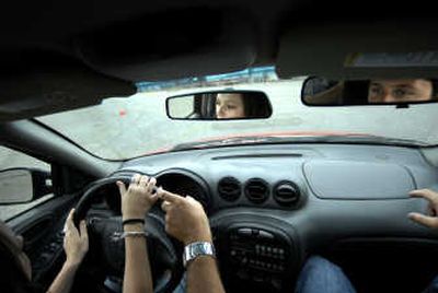 
B&B Driving School instructor Ryan Humphrey grabs the steering wheel to help student Ali Haenny, 16, steer the Skid Monster car on a driving course at the Spokane County Fairgrounds. Driving the Skid Monster is similar to driving on slippery conditions and allows students to practice controlling a skidding vehicle.
 (Photos by JED CONKLIN / The Spokesman-Review)