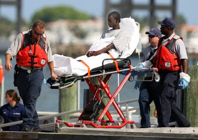 A survivor from a boat that capsized off the coast of Florida is brought into a U.S. Coast Guard Station on Wednesday in Riviera Beach, Fla.  (Associated Press / The Spokesman-Review)