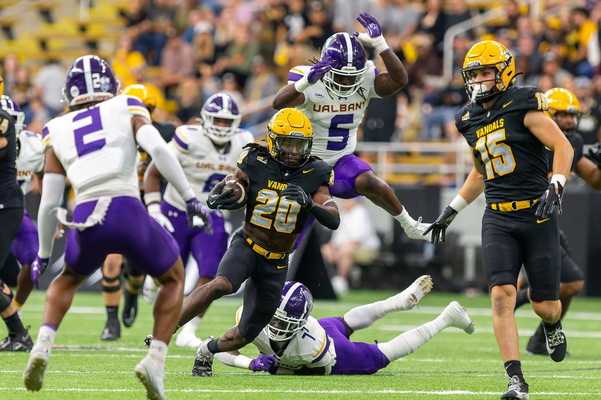 Idaho running back Elisha Cummings (20) slips through a group of UAlbany defenders on Saturday, Sept. 14, 2024 at the Kibbie Dome in Moscow, Idaho.  (Geoff Crimmins/For The Spokesman-Review)