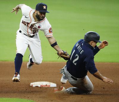 Houston Astros second baseman Jose Altuve, left, catches Seattle Mariners' Evan White trying to steal in the top of the seventh inning Sunday, Aug. 16, 2020, in Houston. (Kevin M. Cox/Galveston County Daily News via AP)