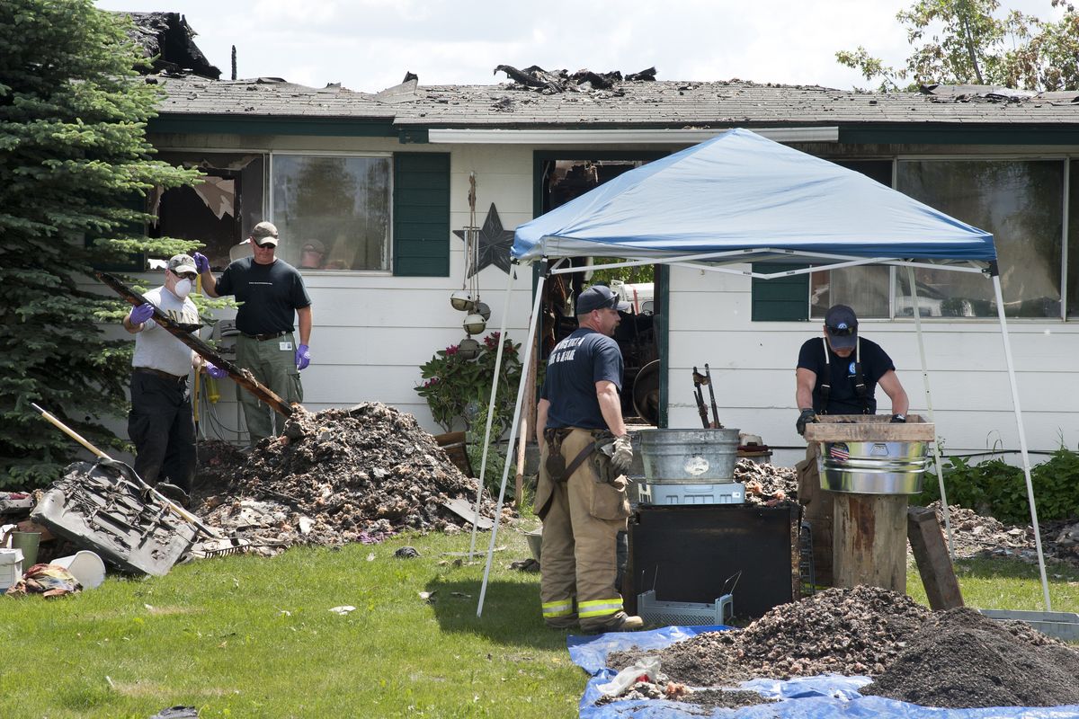 Investigators sift and search through debris Thursday at the Colbert home where three bodies were found in the aftermath of a fire. (Dan Pelle)