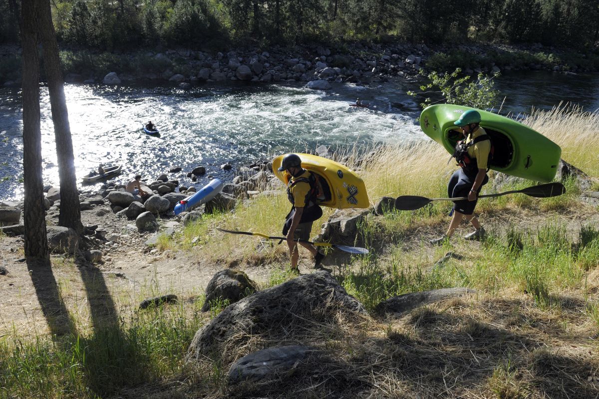 Spokane Valley kayaker Steve Bailey and his paddling partner Mike Hamm walk down the trail to a put in on the upper Spokane River, Mon. evening, August 1, 2011. The pair were headed to "Sullivan Hole", a wave that is a Spokane River low water play spot for whitewater enthusiasts. J. (J. Rayniak / The Spokesman Review)