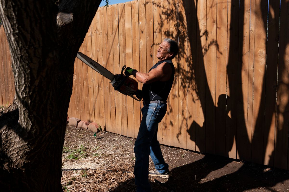 Jerry Dean McLain cuts down a tree in Oklahoma City on April 11. MUST CREDIT: Nick Oxford for The Washington Post (Nick Oxford/For The Washington Post)