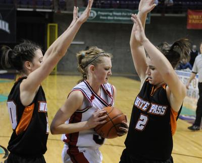 Mikel Elliott, left, and Molly Rashoff of White Pass box in Liberty’s Katy Collins during Thursday night’s game at the Arena.  (Coliln Mulvany / The Spokesman-Review)
