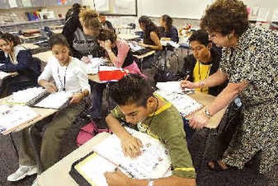
Graciela Pruneda, right, assists Paul Alcaraz Reyes, 18, during a bilingual English class at Othello High School in Othello, Wash. 
 (Associated Press / The Spokesman-Review)