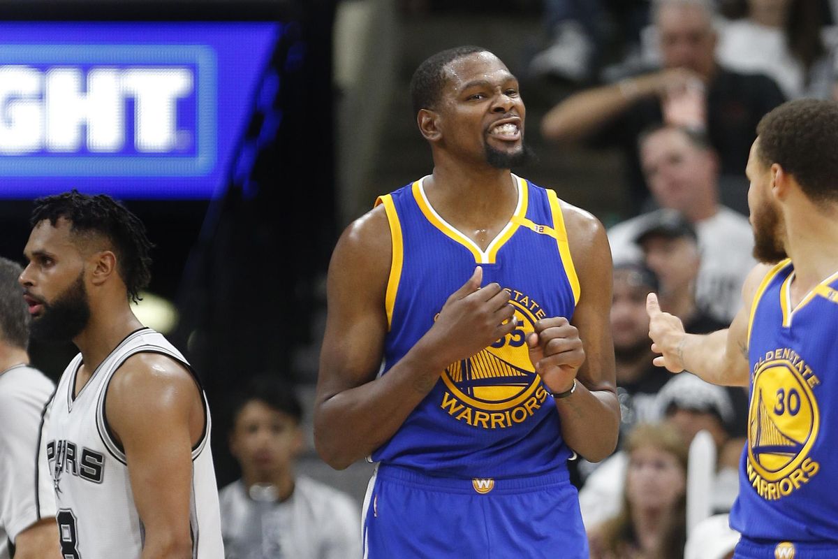 Golden State Warriors forward Kevin Durant (center) and guard Stephen Curry celebrate after a basket during game 3 against San Antonio on Saturday. The Warriors go for the sweep on Monday. (Ronald Cortes / Associated Press)