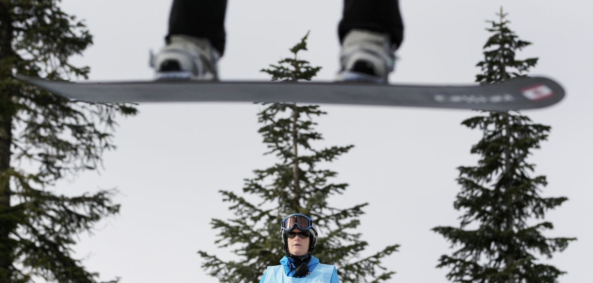 A judge inspects a jump during the first snowboard cross qualification run at the Vancouver 2010 Olympics on Monday, Feb. 15, 2010. (Jae Hong / Associated Press)