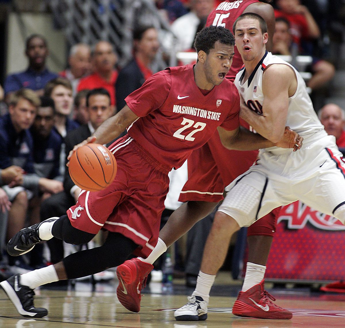 Washington State’s Royce Woolridge drives against T.J. McConnell in the first half. (Associated Press)